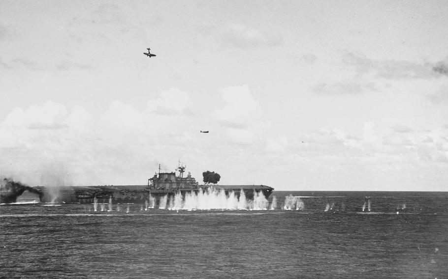 A Japanese dive bomber trails smoke as it dives toward the aircraft carrier USS Hornet on the morning of Oct. 26, 1942. The plane struck the ship's stack and then its flight deck.