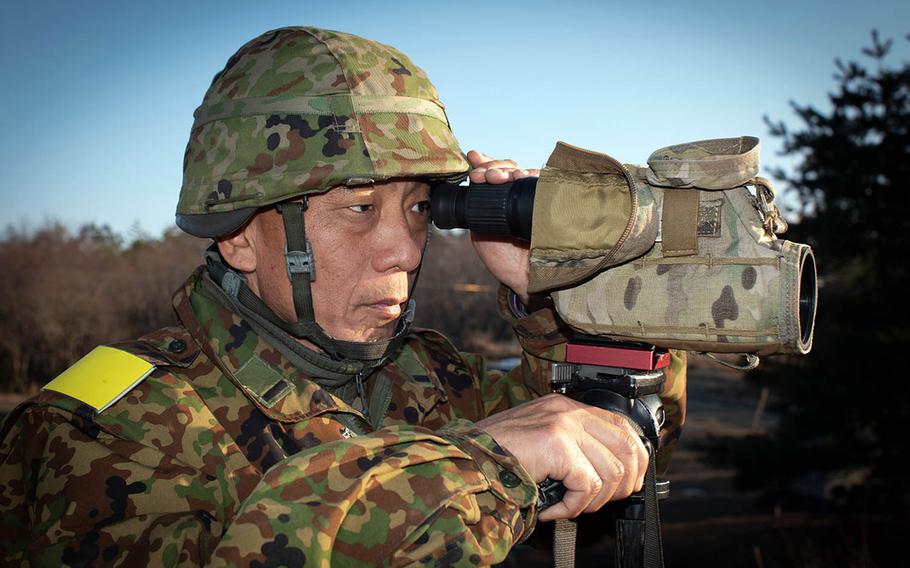A command sergeant major in the Japanese Ground Self-Defense Force 7th Regiment, Middle Army, with a spotting scope inspects shot placement of JGSDF and Marine snipers Feb. 6, 2019, at Aibano Exercise Area near Takashima, Japan, during exercise Forest Light 19-2.