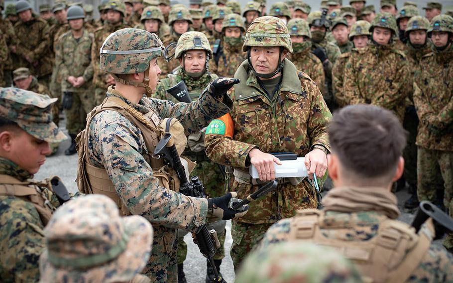 A Marine infantry officer explains Marine methods of urban warfare training to Japan Self-Defense Force soldiers Feb. 7, 2019, during Exercise Forest Light 19-2 at Aibano Exercise Area near Takashima, Japan.