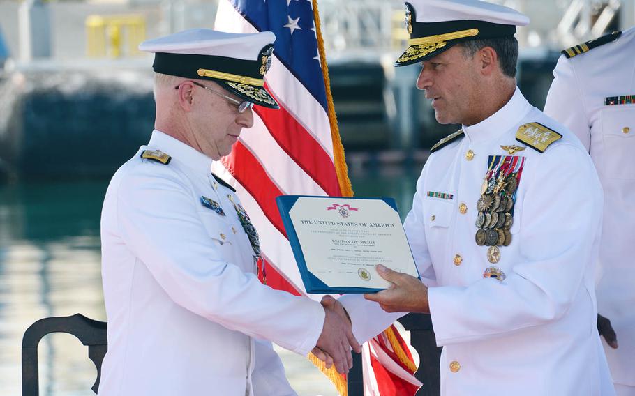 U.S. Pacific Fleet commander Adm. John Aquilino, right, presents a Legion of Merit to Rear Adm. Daryl Caudle at Joint Base Pearl Harbor-Hickam, Hawaii, Thursday, Feb. 21, 2019.