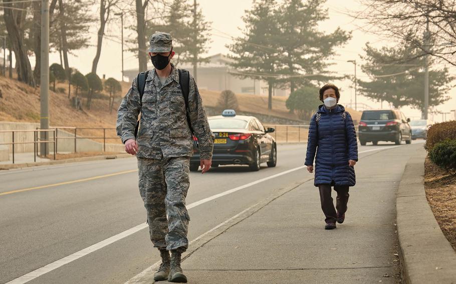 Pedestrians wear air-filtering masks at Osan Air Base, South Korea, Wednesday, March 6, 2019.