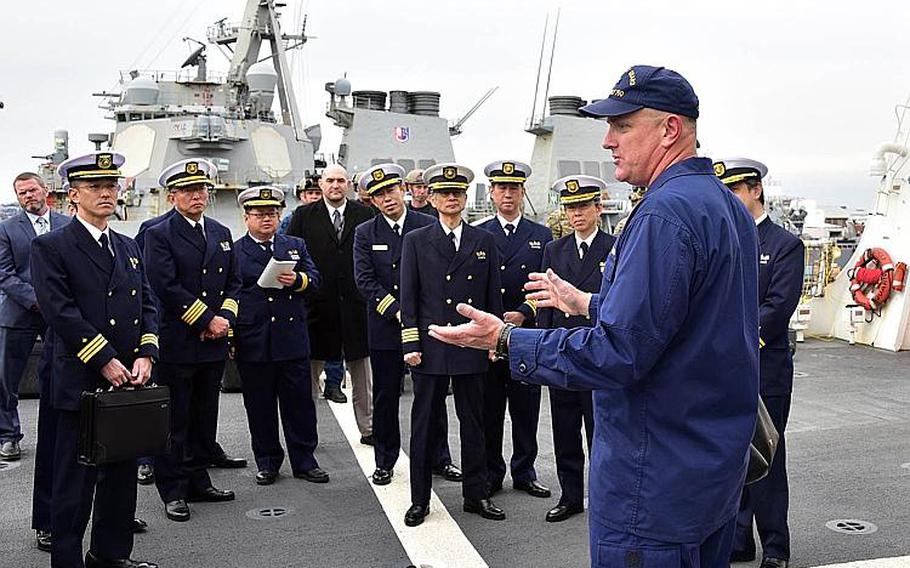 Capt. John Driscoll of the Coast Guard cutter Bertholf speaks to officers from Japan's coast guard on the ship's flight deck, Feb. 7, 2019.