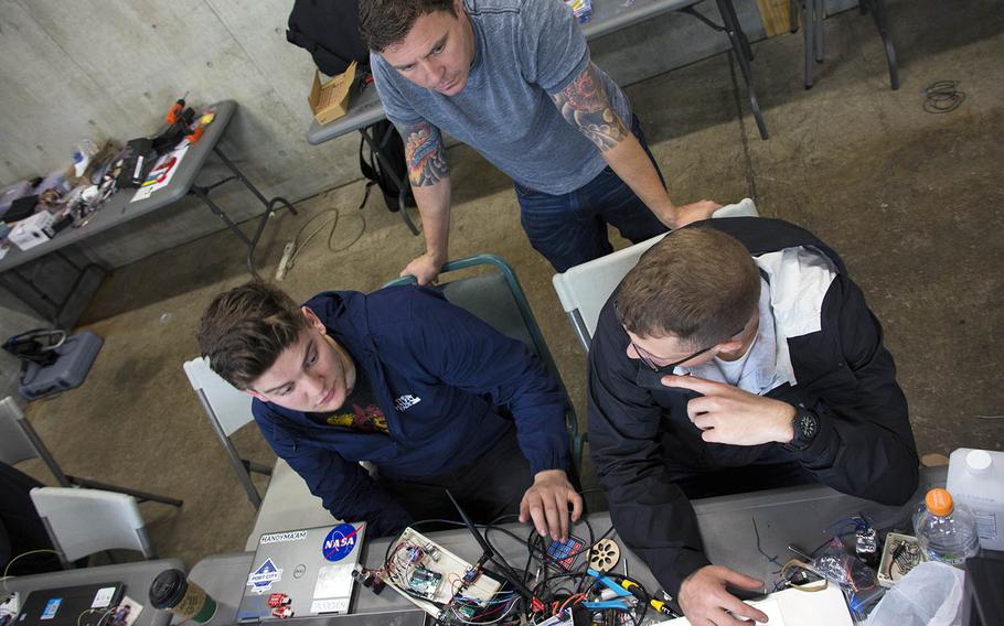 Marines and an instructor from Building Momentum configure a robot during a Marine Maker Innovation Boot Camp at Camp Kinser, Okinawa, Japan, on March 15, 2019.