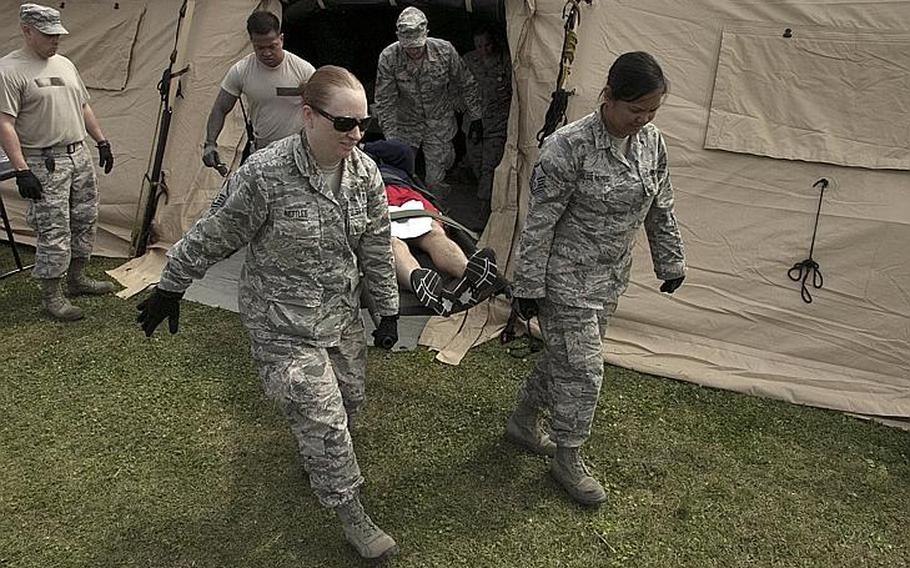 Airmen from the 18th Medical Group carry a simulated casualty to a KC-135 Stratotanker during an exercise at Kadena Air Base, Okinawa, Wednesday, March 27, 2019.