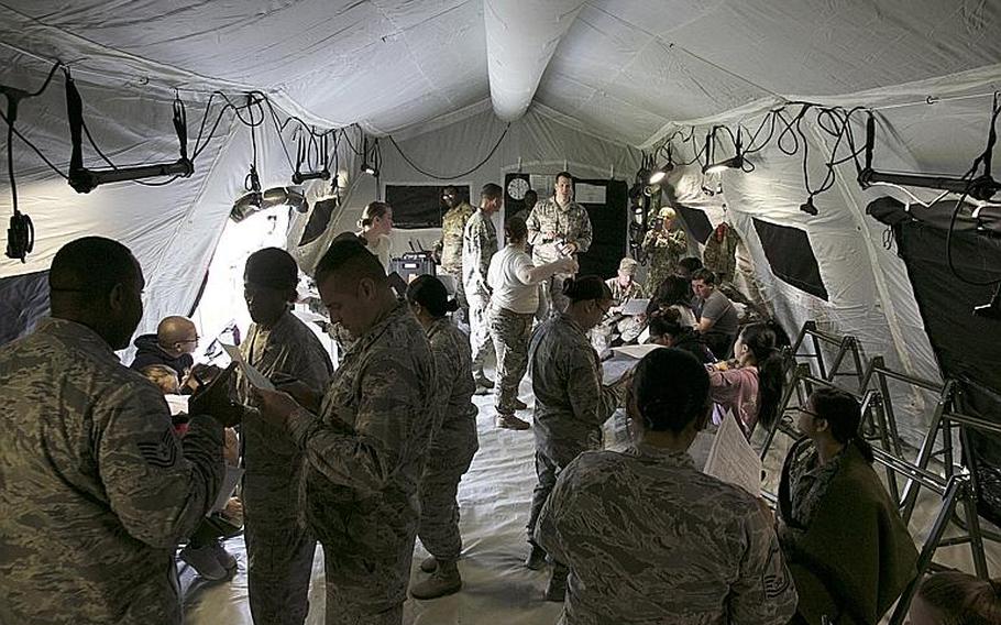 Airmen from the 18th Medical Group in-process simulated casualties inside a pop-up En-Route Patient Staging System and prepare them for travel during an exercise at Kadena Air Base, Okinawa, Wednesday, March 27, 2019.