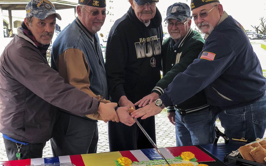 Veterans use a ceremonial sword to cut a cake that honors National Vietnam War Veterans Day at Yokosuka Naval Base, Japan, Friday, March 29, 2019.