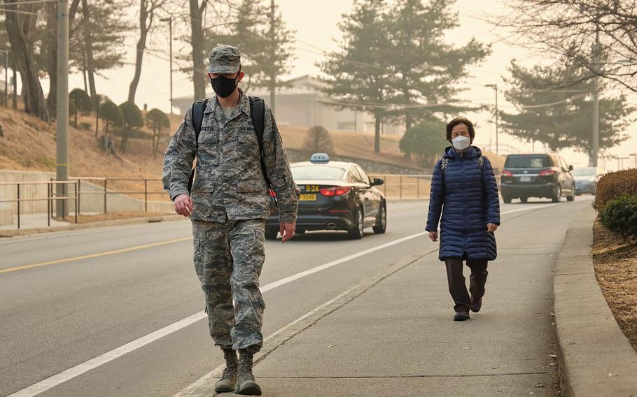 Pedestrians wear air-filtering masks at Osan Air Base, South Korea, March 6, 2019. Since 2017, the Air Force has permitted masks when pollution hit a certain level. But before a recent change, Army regulations had barred most soldiers from wearing filtering masks in uniform.