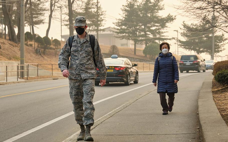 Pedestrians wear air-filtering masks at Osan Air Base, South Korea, March 6, 2019. Since 2017, the Air Force has permitted masks when pollution hit a certain level. But before a recent change, Army regulations had barred most soldiers from wearing filtering masks in uniform. 