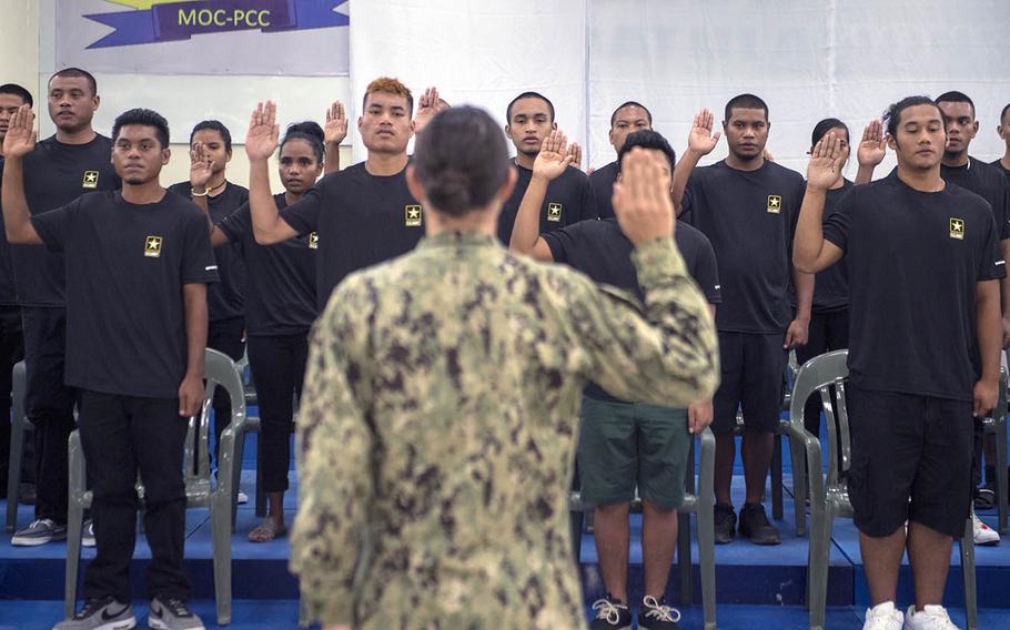 Lt. Cmdr. Gina Becker, commander of Honolulu Military Entrance Processing Station, administers the enlistment oath to enlistees in Koror, Palau, on July 20, 2018.
