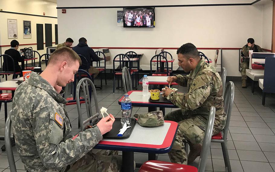 Soldiers eat lunch at the U.S. Army Garrison Yongsan food court while a TV shows sports programming Wednesday, April 10, 2019.