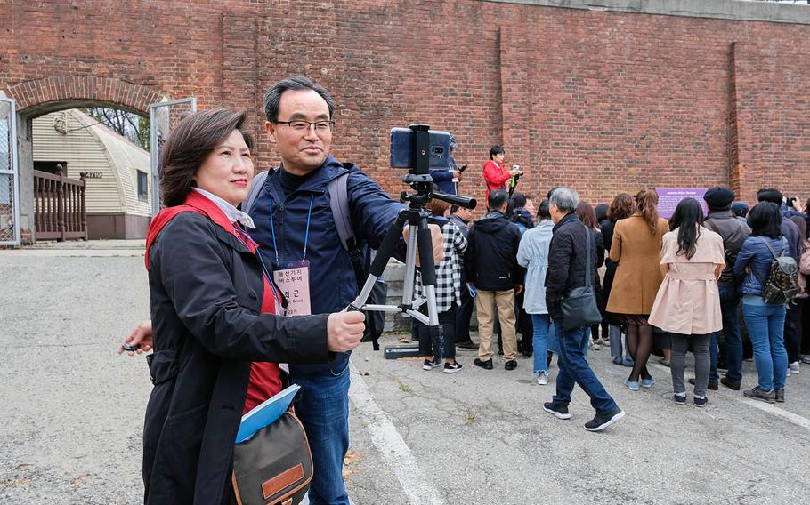 South Korean visitors take a selfie outside the gates of a historic Japanese military stockade located inside Yongsan Garrison, South Korea, on Tuesday, April 9, 2019.