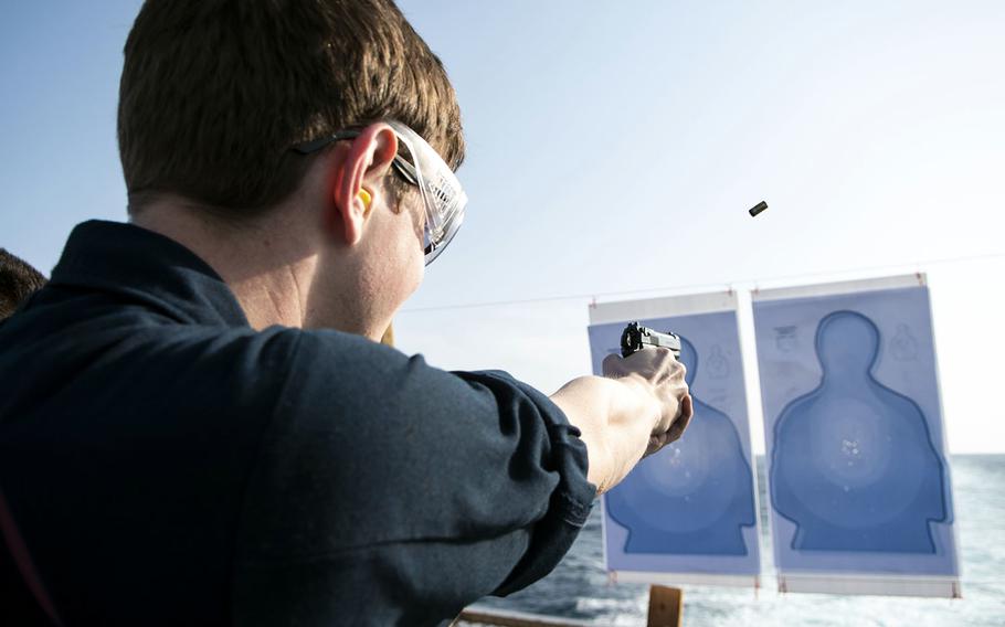 A sailor fires an M9 service pistol during a weapons qualification course in the Philippine Sea aboard the USS Green Bay, March 27, 2019.