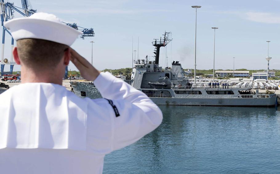 Petty Officer 2nd Class Jacob Crowe salutes the Sri Lankan navy's SLNS Samudura as the USS Spruance pulls into Hambantota, Sri Lanka, April 18, 2019.