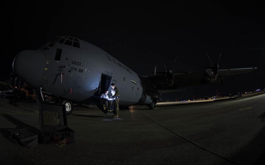 Airman 1st Class Alice Merrill and Senior Airman Mark Kelly review preparations for washing a C-130J Super Hercules at Yokota Air Base, Japan, on March 21, 2019.