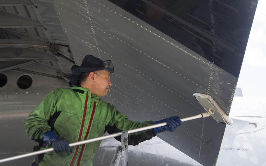 Sugi Yama, a contractor at Yokota Air Base, Japan, washes a C-130J Super Hercules on March 21, 2019.
