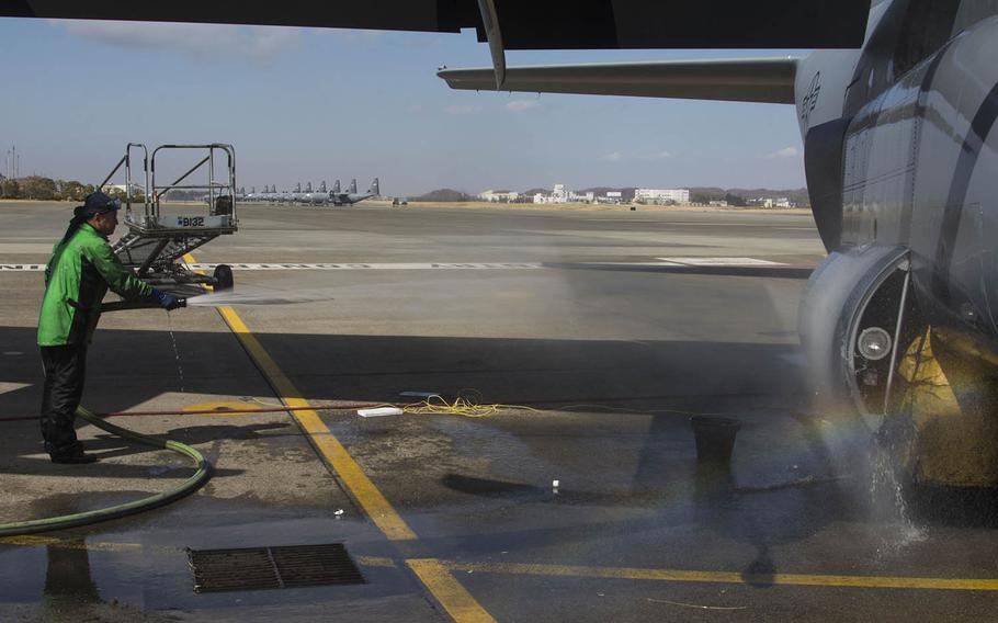 Sugi Yama, a contractor at Yokota Air Base, Japan, rinses a C-130J Super Hercules during a wash on March 21, 2019.