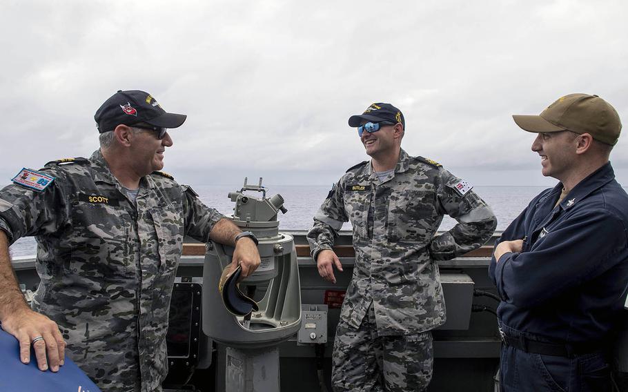 Sailors of the  U.S. and Australian navies share conversation aboard the USS Preble during exercises on the Philippine Sea on Thursday, April 18, 2018.