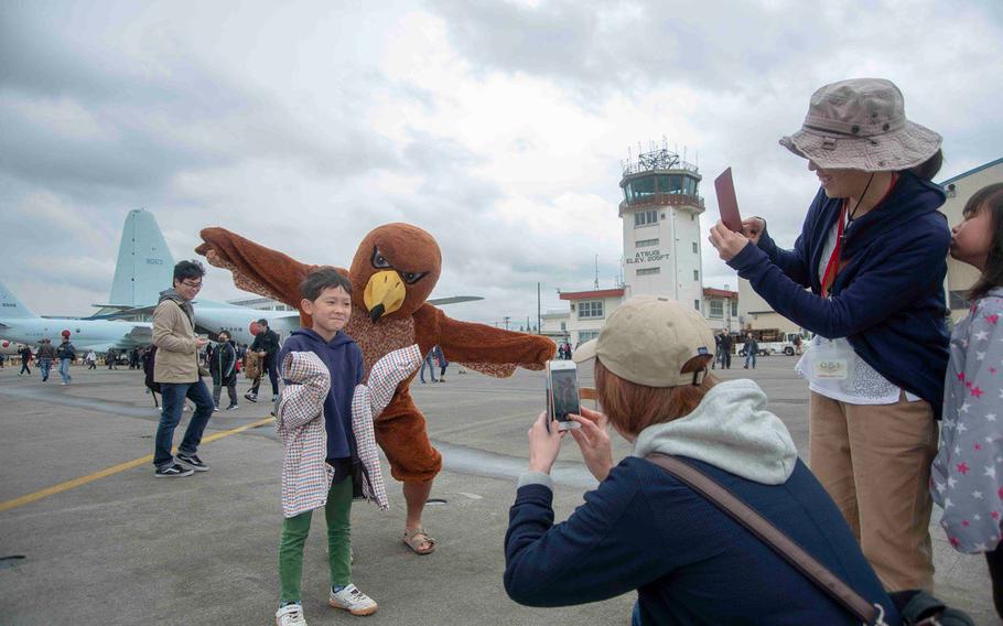 A mascot for Helicopter Maritime Strike Squadron 77 poses with a guest during the Spring Festival at Naval Air Facility Atsugi, Japan, Saturday, April 27, 2019.