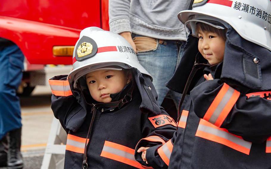 Children try on Japanese firefighter gear during the Spring Festival at Naval Air Facility Atsugi, Japan, Saturday, April 27, 2019.