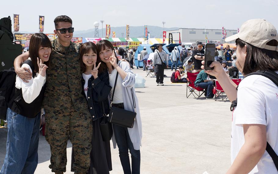 A Marine poses with visitors during the Friendship Day 2019 at Marine Corps Air Station Iwakuni, Japan, Sunday, May 5, 2019.