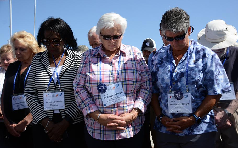 Annie Winstead, Tracey Province and Melanie Mikeska join other relatives of missing American servicemembers in a moment of silence, May 29, 2019, during a visit to the Korean War battleground known as Arrowhead Hill for a rare view of the site in the Demilitarized Zone where South Korea is excavating for remains.
