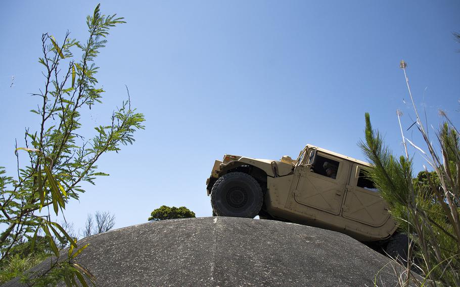 Marines maneuver a Humvee over an obstacle during an Advanced Motor Vehicle Operations Course at Camp Schwab, Okinawa, May 23, 2019.