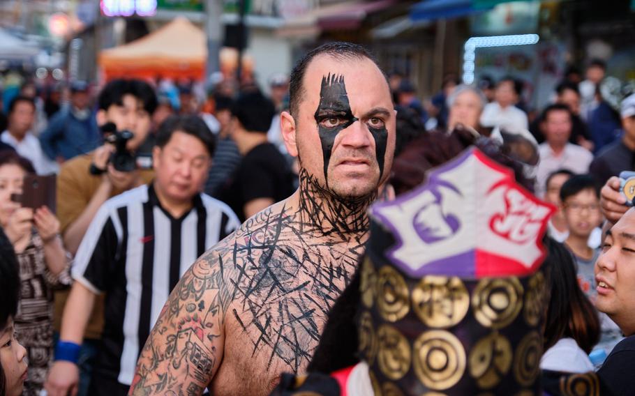 Tech. Sgt. Gregory Gauntt of the 8th Logistics Readiness Squadron at Kunsan Air Base walks behind his Japanese teammate, Masakado, before their tag-team wrestling match in Goyang, South Korea, June 2, 2019.