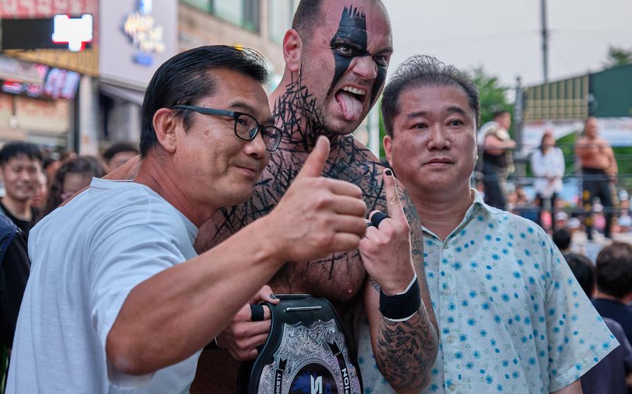 Tech. Sgt. Gregory Gauntt of the 8th Logistics Readiness Squadron at Kunsan Air Base poses with fans after a tag-team wrestling match in Goyang, South Korea, June 2, 2019.