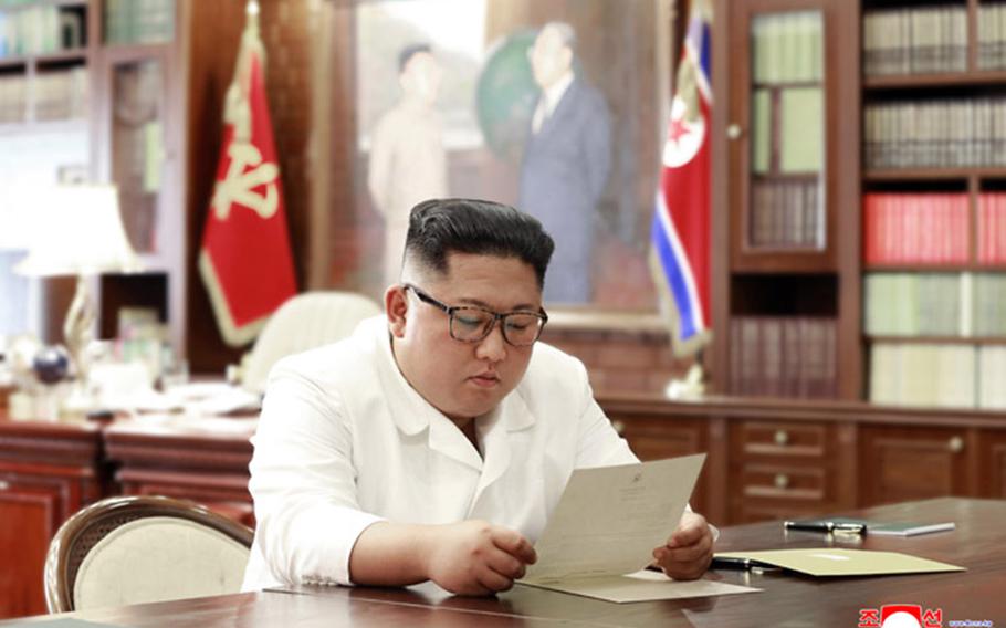 North Korean leader Kim Jong Un reads a letter purportedly from President Donald Trump in this undated photo released by the Korean Central News Agency.