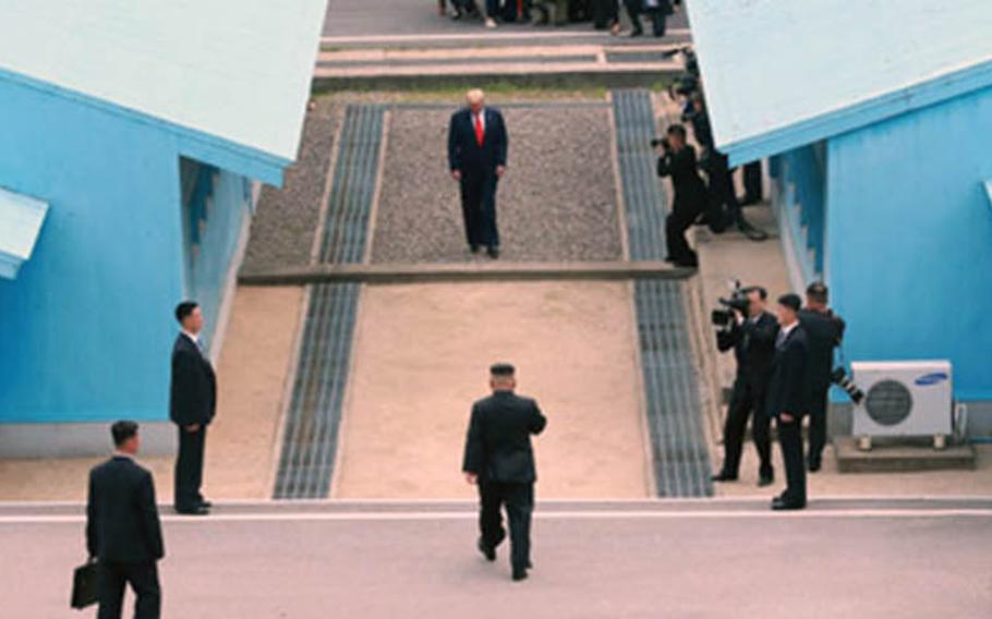 North Korean leader Kim Jong Un walks toward U.S. President Donald Trump, waiting at the berm separating North and South Korea, on Sunday, June 30, 2019.