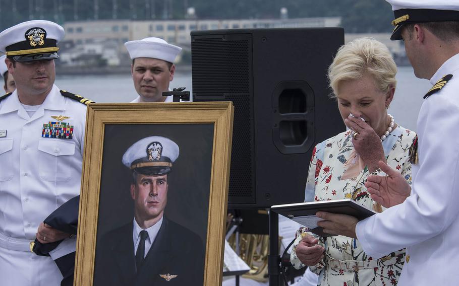Cmdr. Micah Murphy of the USS John S. McCain presents Cindy McCain with the commissioning pennant after the unveiling a portrait of her late husband, Sen. John McCain, aboard the ship at Yokosuka Naval Base, Japan, Tuesday, July 2, 2019.