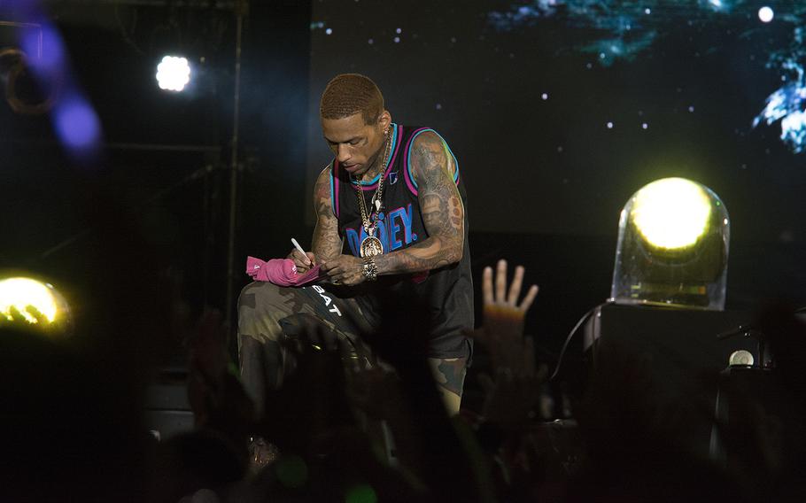 Rapper Kid Ink autographs a T-shirt during a performance at Camp Foster, Okinawa, Sunday, July 7, 2019.