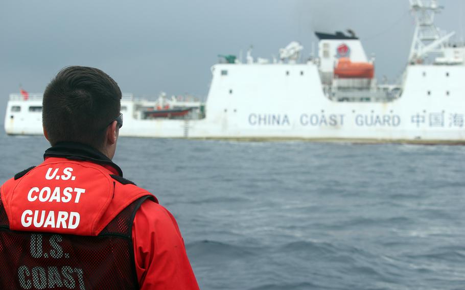 A member of the U.S. Coast Guard watches a China Coast Guard vessel in the Sea of Japan, also known as the East Sea, June 21, 2018.