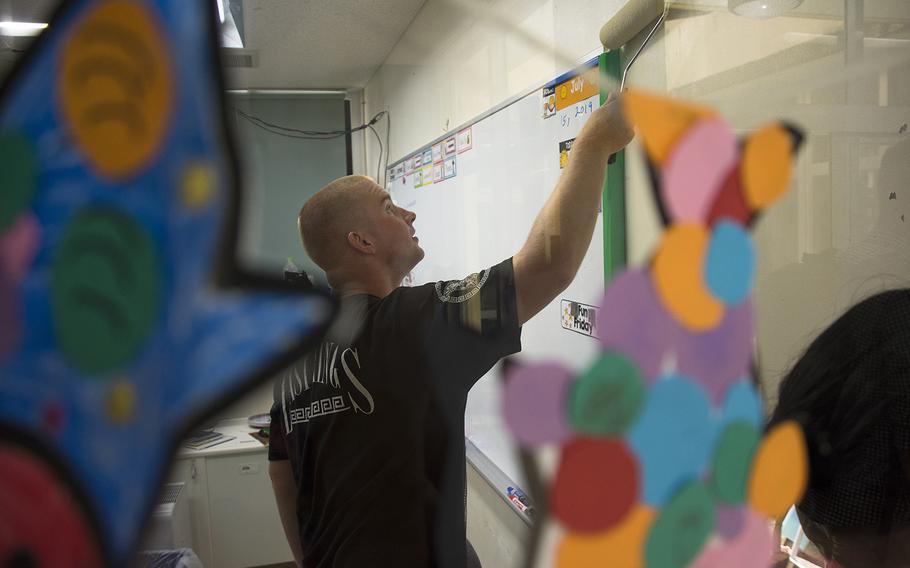 A Marine assigned to Combat Logistics Battalion 4 paints a classroom at the AmerAsian School in Ginowan, Okinawa, Monday, July 15, 2019.