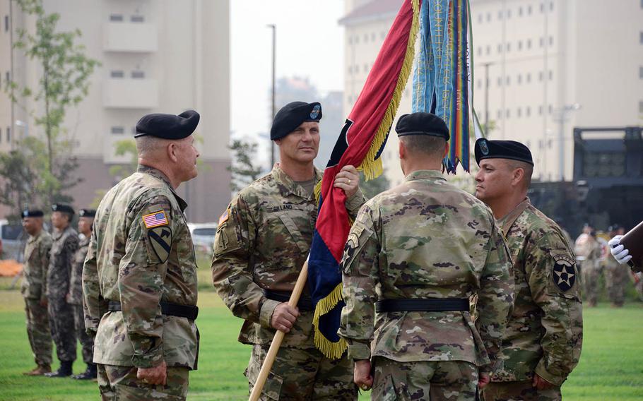 Maj. Gen. Steve Gilland accepts the 2nd Infantry Division colors from Eighth Army commander Lt. Gen. Michael Bills, left, at Camp Humphreys, South Korea, Wednesday, July 17, 2019.