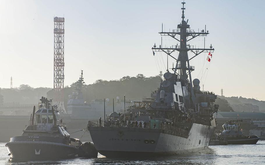 The USS John S. McCain is pulled toward a pier after leaving dry dock at Yokosuka Naval Base, Japan, Nov. 27, 2018. Ten McCain sailors were killed Aug. 21, 2017, when the guided-missile destroyer collided with a commercial vessel near Singapore.