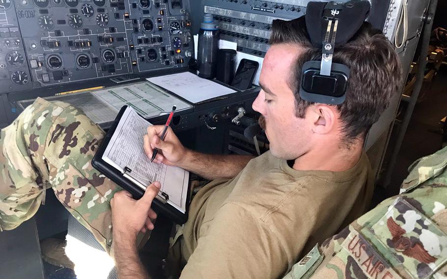 Air Force Staff Sgt. Ben Clouse, a flight engineer, writes notes on Talisman Sabre refueling operations in the cockpit of a KC-10 Extender, Friday, July 19, 2019.