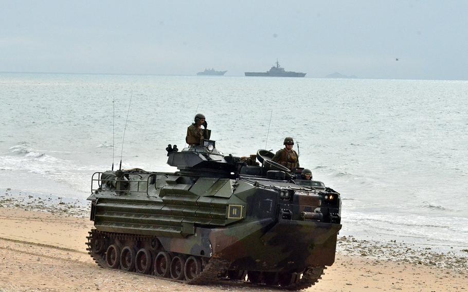 A Marine Corps amphibious-assault vehicle moves down Kings Beach, Australia, during a Talisman Sabre drills, Monday, July 22, 2019. The closest ship in the background is the JS Kunisaki, a Japanese tank landing ship. To its left is Australia's HMAS Adelaide.