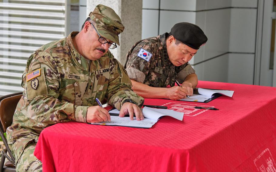 Col. Garrett Cottrell, of the Army Corps of Engineers, Far East District, and Col. Lee Woo-sig, representing the South Korean government, sign documents during a ceremony marking the U.S. government acceptance of the Brian D. Allgood Army Community Hospital at Camp Humphreys, South Korea, Wednesday, July 24, 2019.