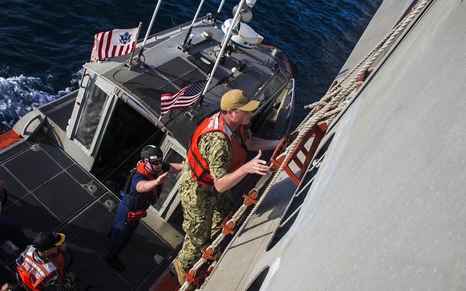 Lt. Ben Ralen of Destroyer Squadron 7 climbs aboard the USS Montgomery during a passenger transfer as part of Cooperation Afloat Readiness and Training Indonesia 2019 on Aug. 5, 2019.