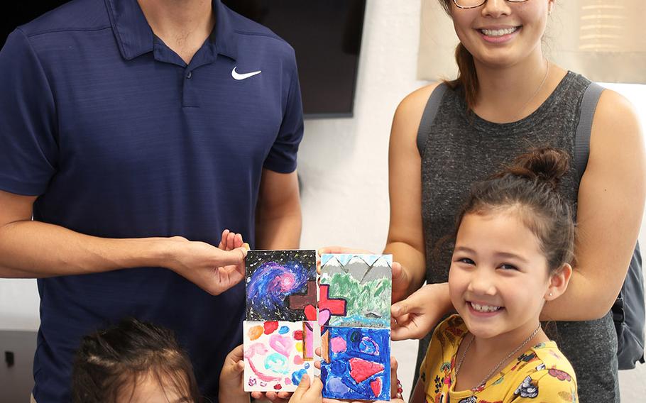 Marine Maj. Sam Wuornos, his wife, Christine, and daughters Evie, 7, and Ella, 4, show off a project they completed from a USO Family Activity Box at Camp Foster, Okinawa, Wednesday, Aug. 28, 2019.