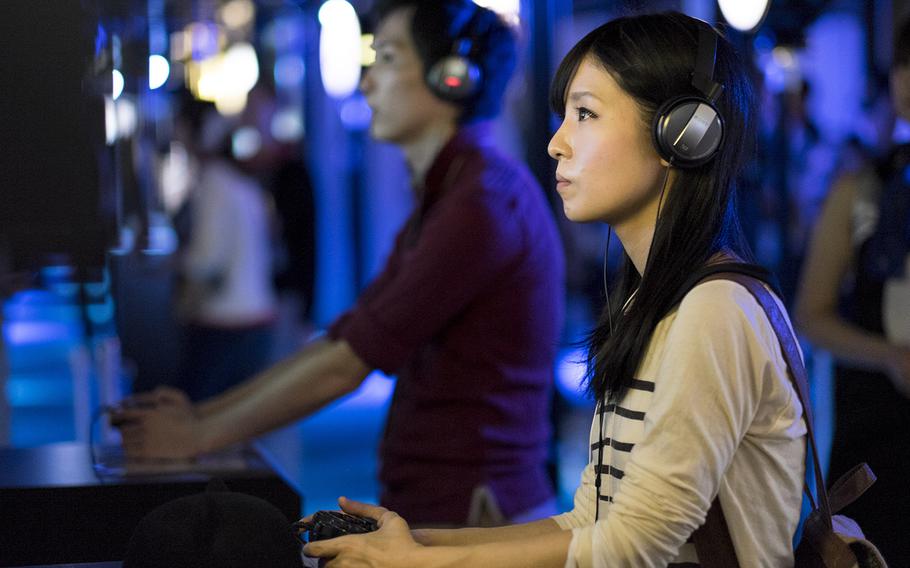 Gamers preview a title at the Sony Playstation booth during a past Tokyo Game Show in Makuhari, Japan.