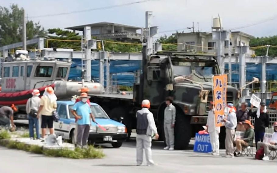 A screenshot from a YouTube video shows some who protested a Marine Corps boat entering Motobu Port on Okinawa, Japan, blocking the truck hauling the vessel on Tuesday, Sept. 17, 2019.