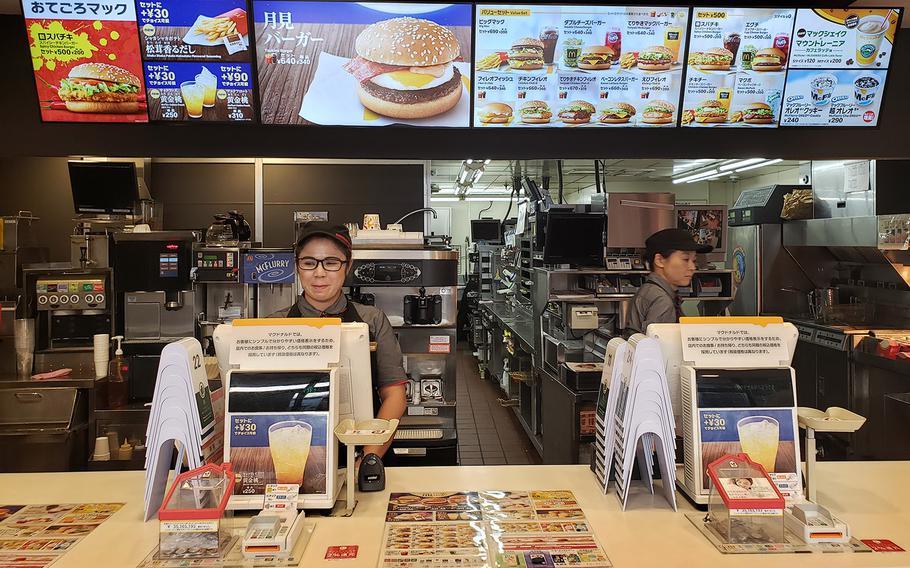 Signs above cash registers at a McDonald's near Yokota Air Base, Japan, explain new pricing after the country's 10% consumption tax took effect, Tuesday, Oct. 1, 2019.