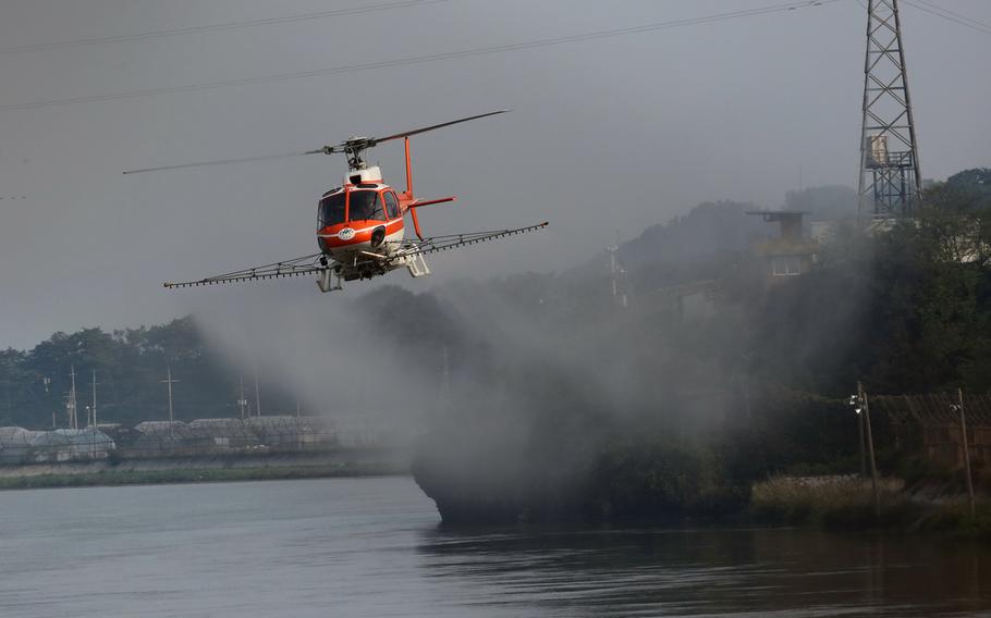A Korea Forest Service helicopter sprays a decontamination solution to fight African swine fever near Gimpo, South Korea, Oct. 1, 2019.
