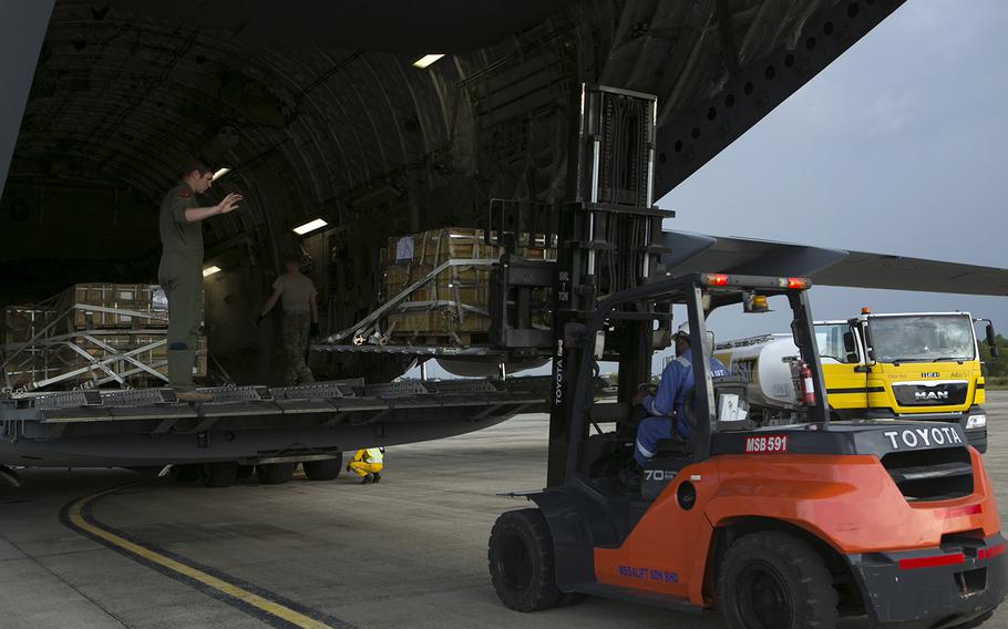 Air Force and Royal Brunei Armed Forces personnel unload pallets of ammunition from a C-17 Globemaster III at Brunei International Airport, Oct. 4, 2019.