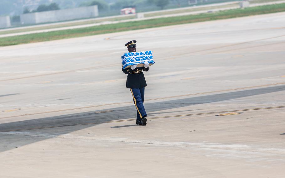 Staff Sgt. Jamil Green carries a case of remains handed over by North Korea at Osan Air Base, South Korea, July 27, 2018.