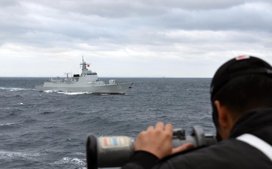A member of the Japan Maritime Self-Defense Force working aboard the destroyer JS Samidare looks at the Chinese guided-missile destroyer Taiyuan during a joint exercise south of Japan last week.