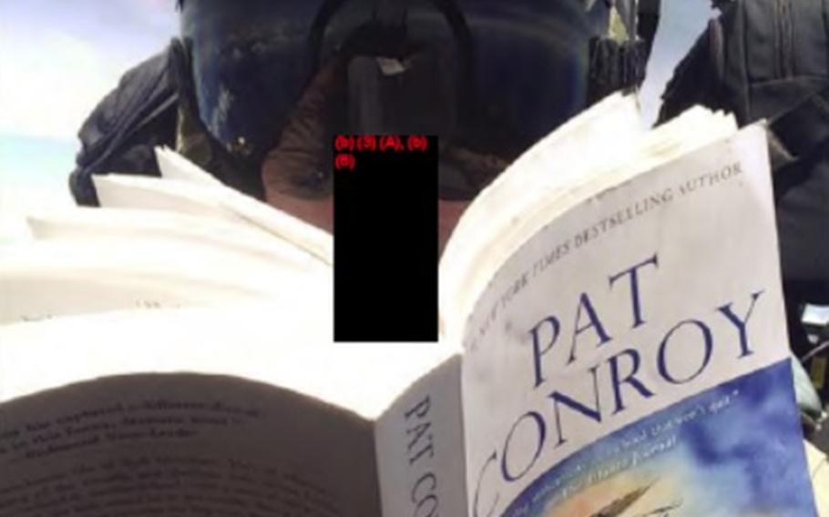 An aviator with Marine All-Weather Fighter Attack Squadron 242 at Marine Corps Air Station Iwakuni, Japan, reads "The Great Santini" by Pat Conroy in an in-flight photo included with a report into a midair collision off Japan in December 2018.
