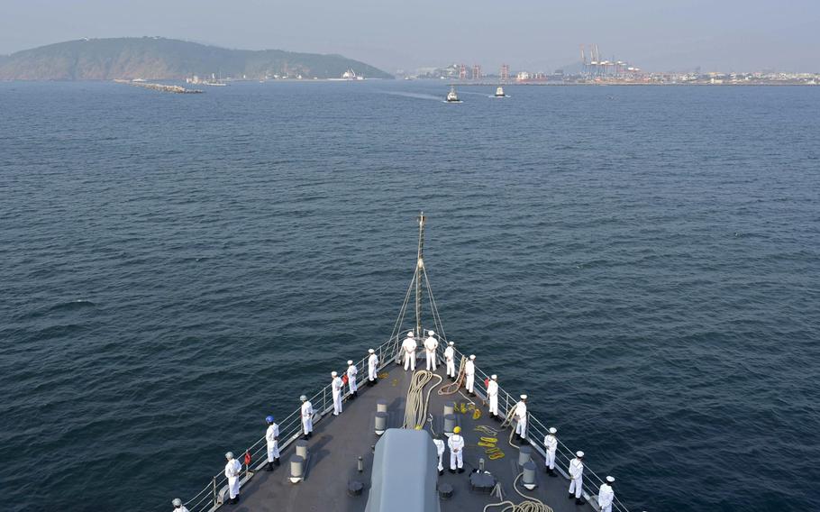 Sailors aboard the Whidbey Island-class dock landing ship USS Germantown man the rails as the ship pulls into Visakhapatnam, India, as part of exercise Tiger Triumph on Nov. 13, 2019.